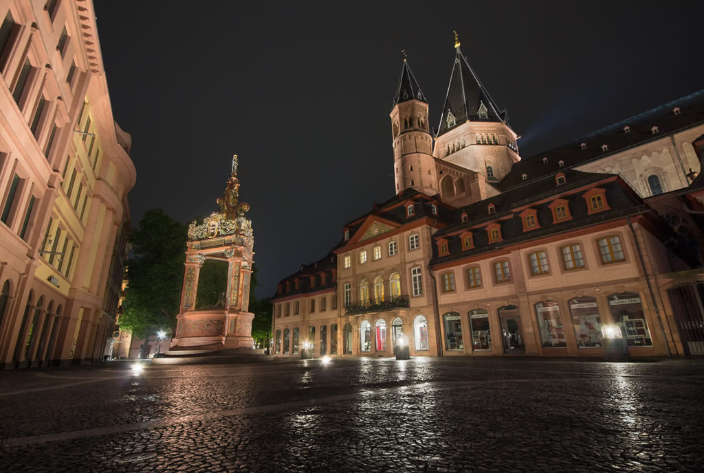 Mainzer Dom angeleuchtet bei Nacht mit nassen spiegelnden Pflastersteinen