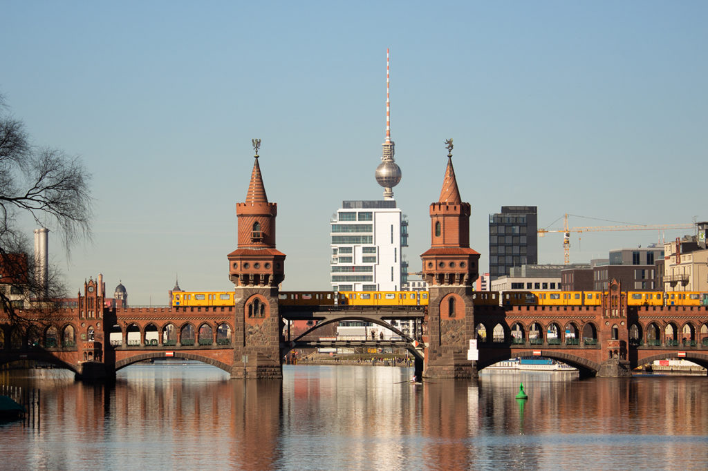 Oberbaumbrücke in Berlin mit fahrender U-Bahn und Fernsehturm im Hintergrund