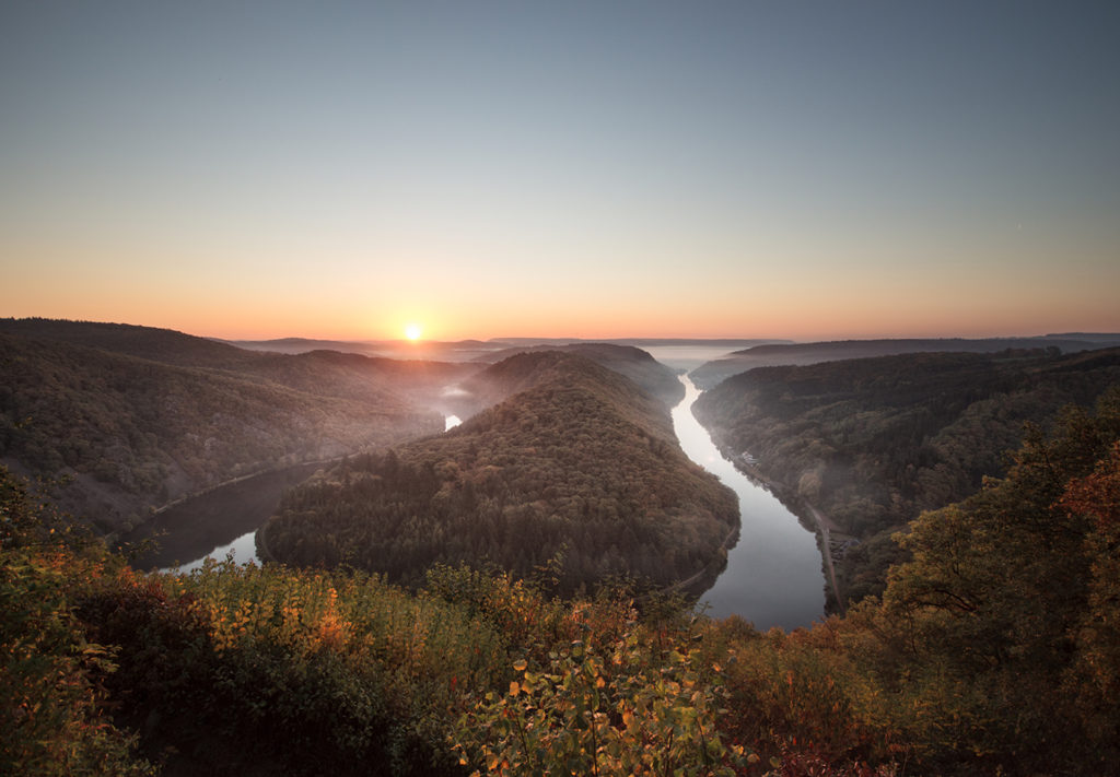 Saarschleife bei Orscholz bei Sonnenaufgang mit Nebelschleier und spiegelndem Wasser