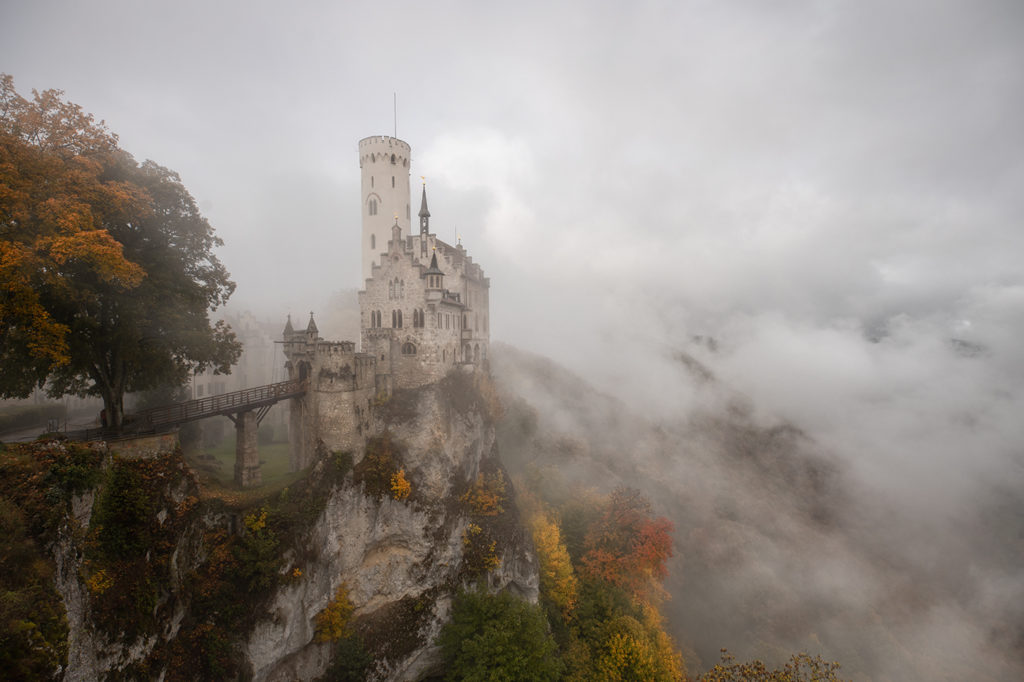 Mystisches Schloss Lichtenstein von Nebel umgeben mit herbstlichen goldenen Bäumen